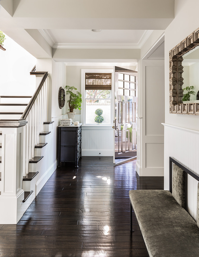 This is an example of a classic foyer in Los Angeles with beige walls, dark hardwood flooring, a single front door and a metal front door.