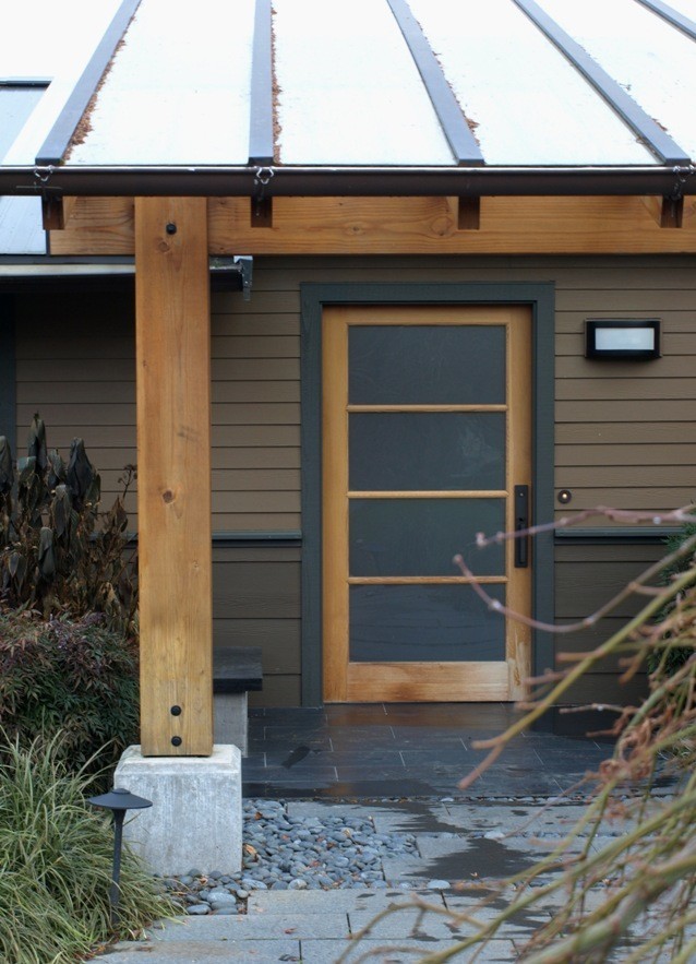 Example of a mid-sized trendy slate floor entryway design in Seattle with brown walls and a glass front door