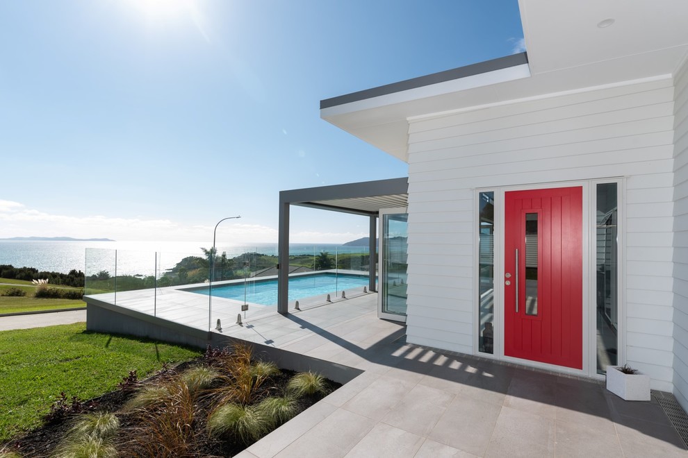 Идея дизайна: входная дверь среднего размера в стиле модернизм с белыми стенами, полом из керамогранита, одностворчатой входной дверью, красной входной дверью и серым полом
