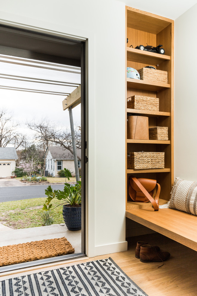 Kleine Skandinavische Haustür mit weißer Wandfarbe, hellem Holzboden, Einzeltür, blauer Haustür und braunem Boden in Austin