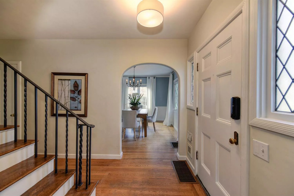 Klassischer Eingang mit Korridor, weißer Wandfarbe, braunem Holzboden, Einzeltür, weißer Haustür und buntem Boden in Sacramento