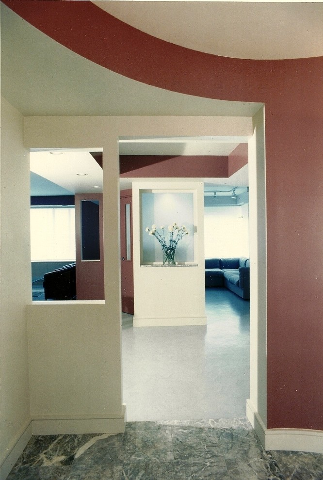 На фото: огромное фойе в стиле модернизм с красными стенами, мраморным полом, одностворчатой входной дверью и белой входной дверью с