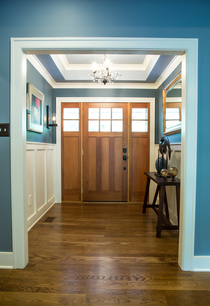 Ispirazione per una porta d'ingresso classica con pareti blu, pavimento in legno massello medio, una porta singola e una porta in legno bruno