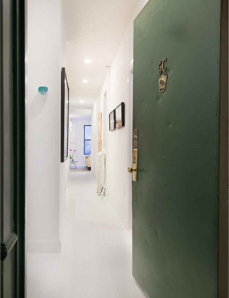 Idee per un piccolo corridoio minimalista con pareti bianche, pavimento in legno verniciato, una porta singola e una porta verde