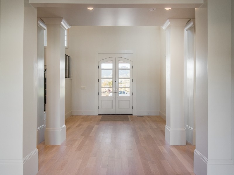 Exemple d'un grand hall d'entrée craftsman avec un mur blanc, parquet clair, une porte double et une porte blanche.