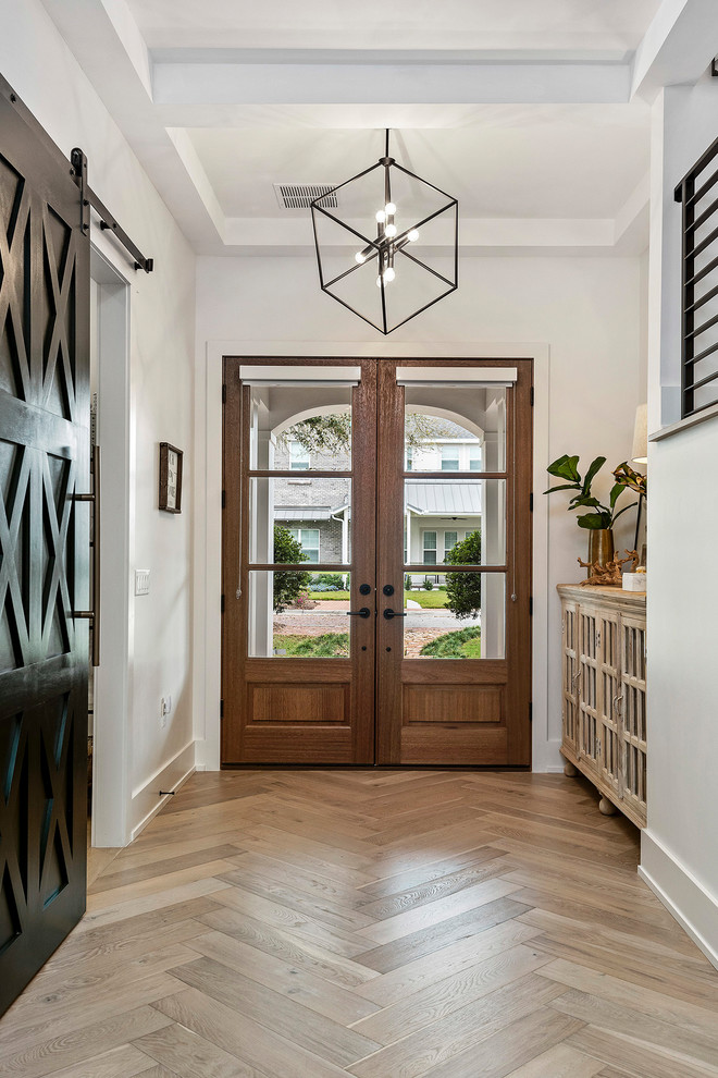Inspiration pour un grand hall d'entrée avec parquet clair, une porte double et une porte en bois brun.