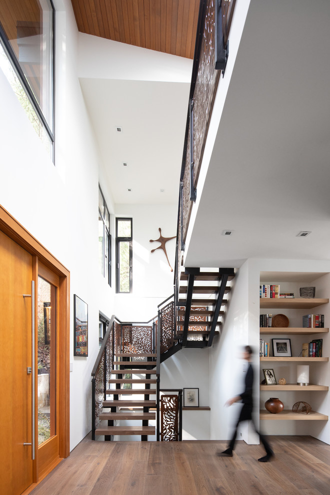 Inspiration for a large contemporary medium tone wood floor and brown floor entryway remodel in Vancouver with white walls and a light wood front door