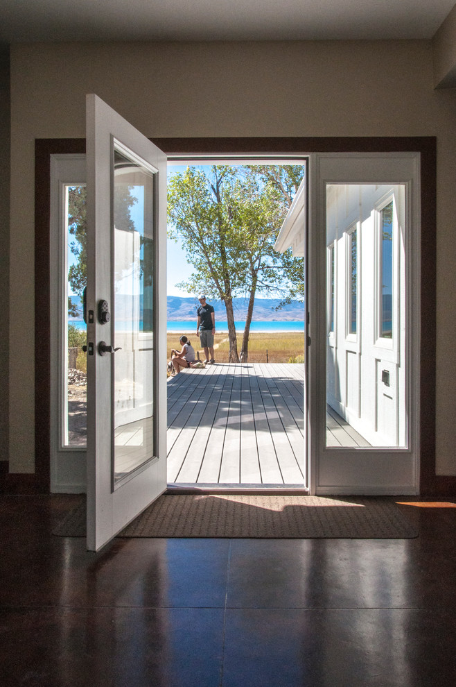 Idee per una piccola porta d'ingresso country con pavimento in cemento, una porta singola, una porta bianca e pareti beige
