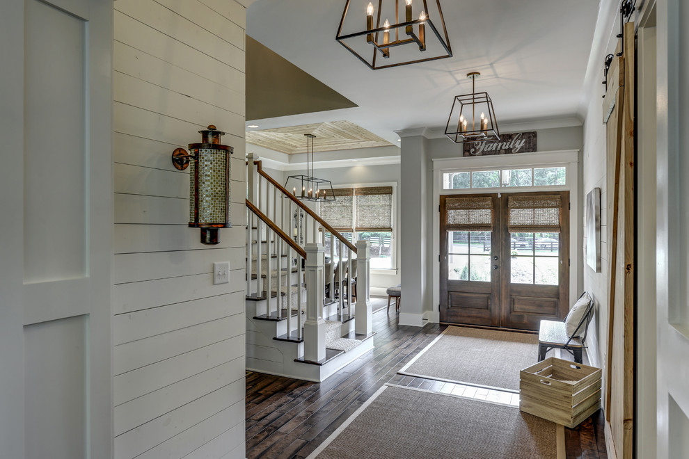 This is an example of a farmhouse hallway in Atlanta with grey walls, dark hardwood flooring, a double front door, a dark wood front door and brown floors.