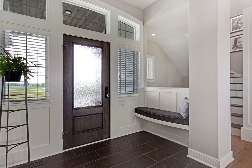 Entryway - transitional ceramic tile entryway idea in Grand Rapids with white walls and a medium wood front door