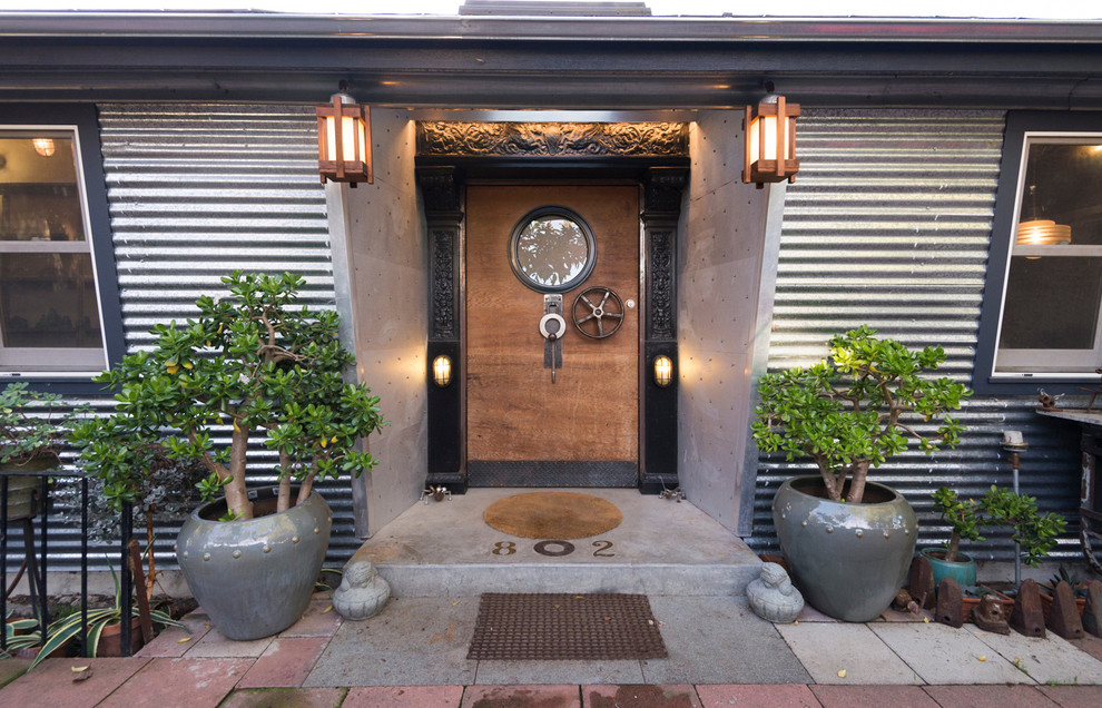 Idée de décoration pour une porte d'entrée bohème avec une porte simple et une porte en bois brun.