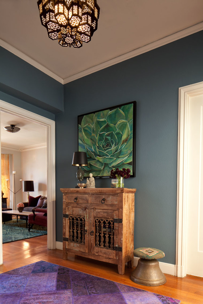 Inspiration for a mid-sized eclectic medium tone wood floor entryway remodel in San Francisco with blue walls and a white front door