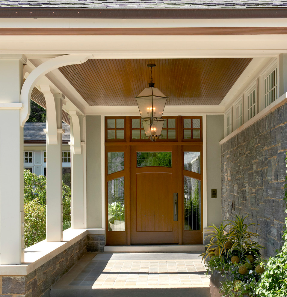 На фото: входная дверь среднего размера в классическом стиле с одностворчатой входной дверью, входной дверью из дерева среднего тона и полом из сланца