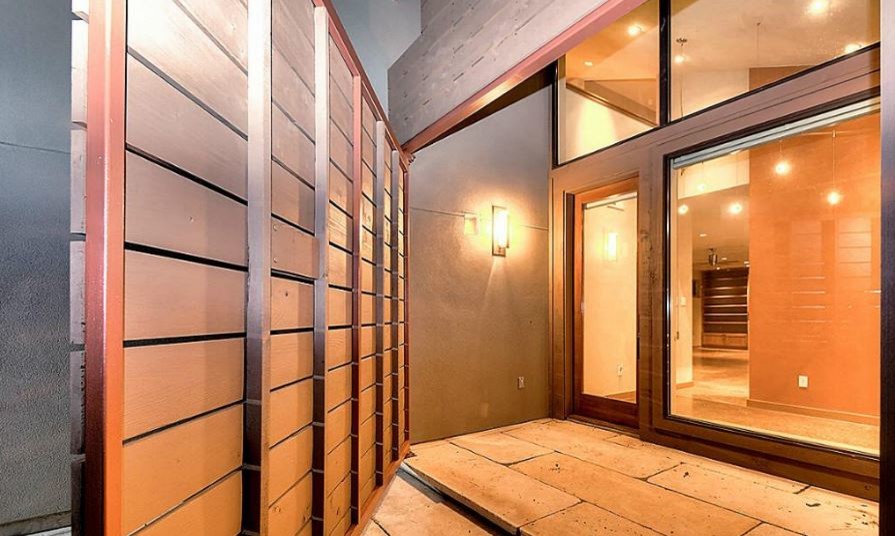 Cette image montre une porte d'entrée minimaliste de taille moyenne avec un mur gris, tomettes au sol, une porte simple et une porte en verre.