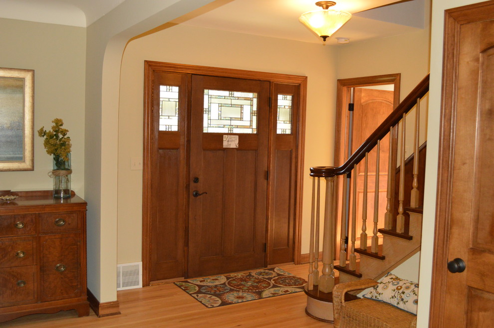 Ispirazione per una porta d'ingresso stile americano di medie dimensioni con pareti beige, pavimento in legno massello medio, una porta singola e una porta in legno scuro