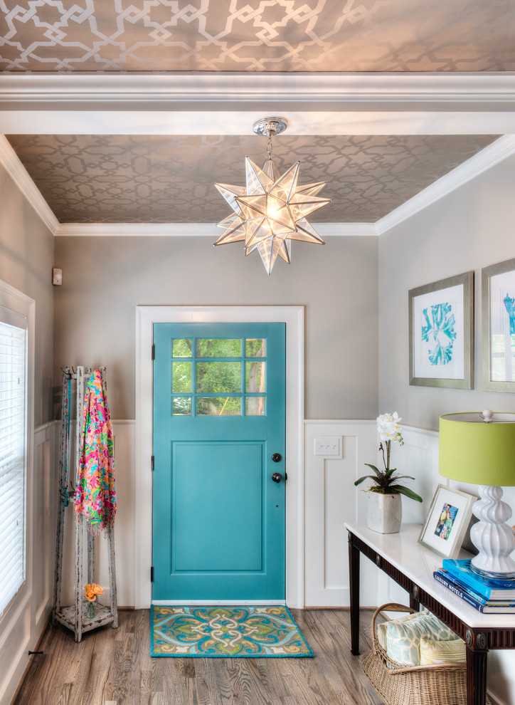 Example of a small classic medium tone wood floor entryway design in Other with gray walls and a blue front door