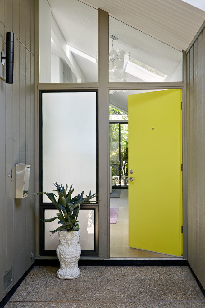 Aménagement d'une porte d'entrée rétro avec une porte simple et une porte jaune.