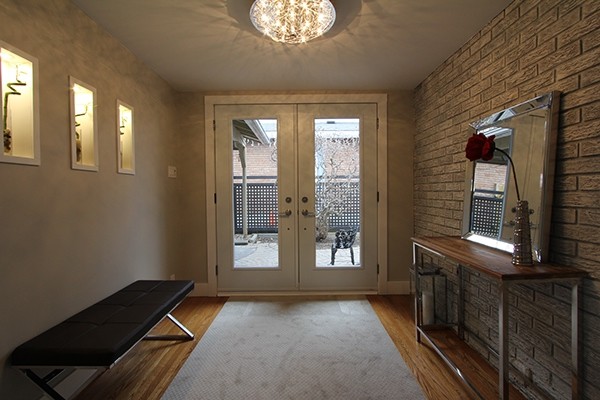 Cette photo montre une petite porte d'entrée tendance avec un mur gris, un sol en bois brun, une porte double et une porte blanche.
