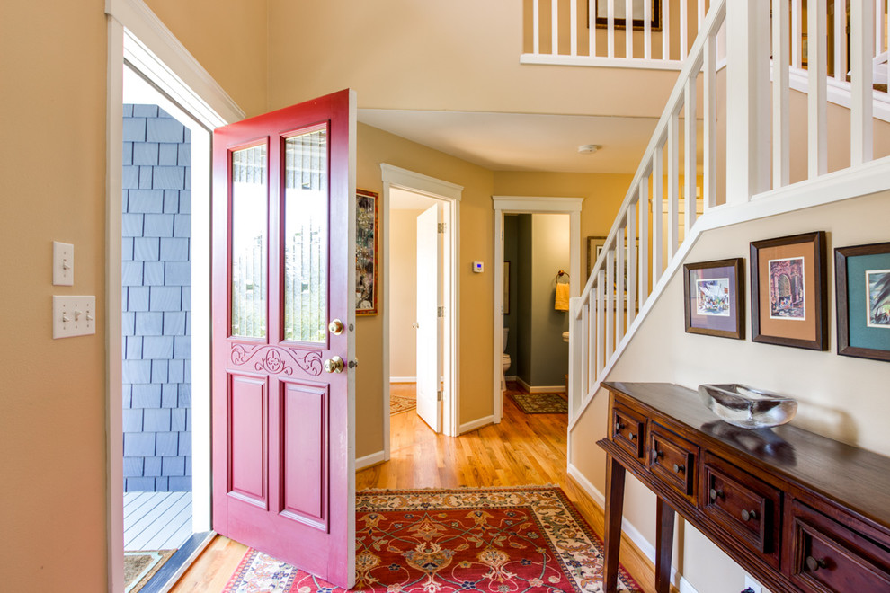На фото: фойе среднего размера в классическом стиле с бежевыми стенами, паркетным полом среднего тона, одностворчатой входной дверью и красной входной дверью с