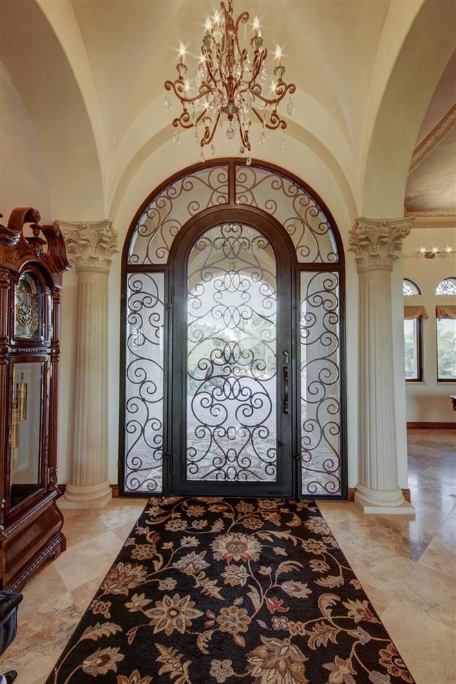 Ejemplo de distribuidor mediterráneo grande con paredes beige, suelo de baldosas de porcelana, puerta simple, puerta de vidrio y suelo beige