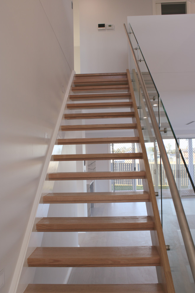 Large modern staircase in Sydney with panelled walls.