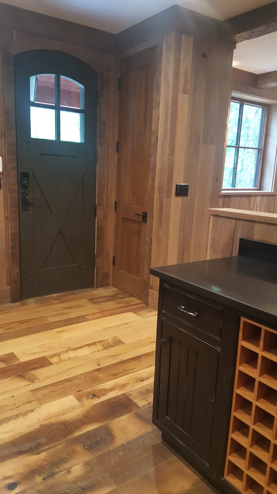 Große Urige Haustür mit brauner Wandfarbe, braunem Holzboden, Einzeltür, schwarzer Haustür und braunem Boden in New York