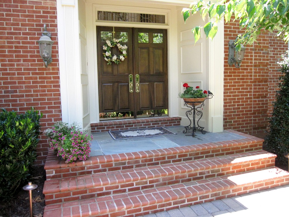 ワシントンD.C.にあるお手頃価格の小さなトラディショナルスタイルのおしゃれな玄関ドア (ベージュの壁、レンガの床、濃色木目調のドア) の写真