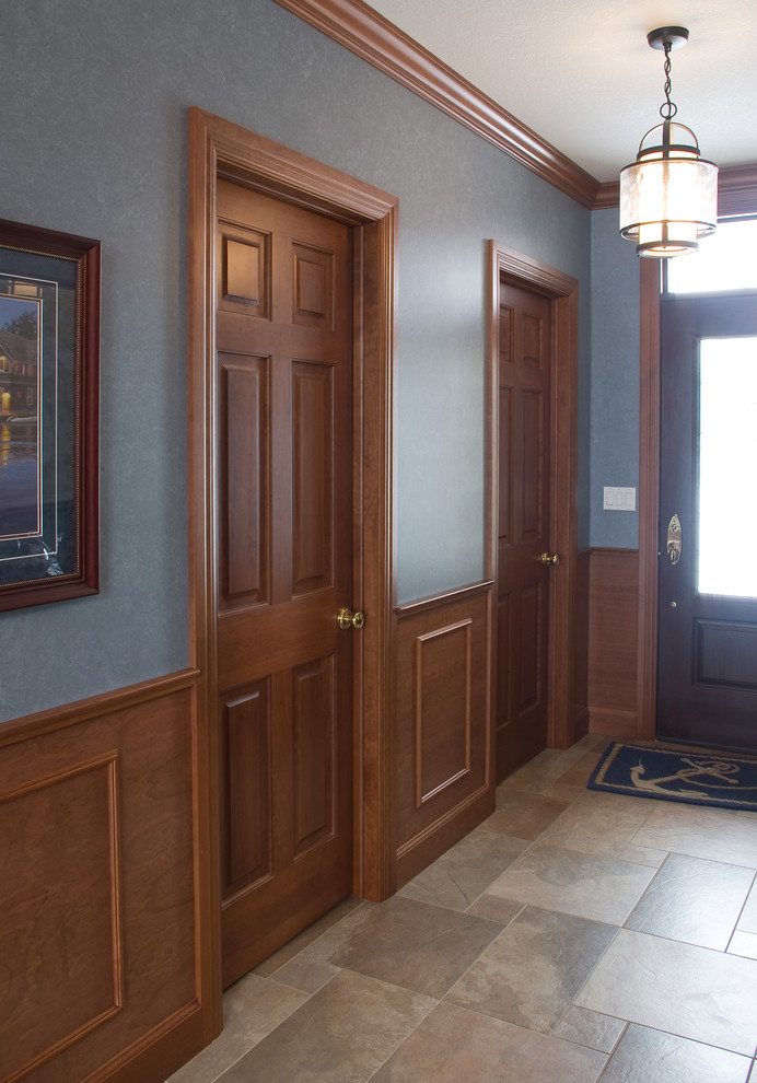 Ispirazione per un ingresso tradizionale con pareti blu, pavimento in gres porcellanato, una porta singola, una porta in legno scuro e pavimento grigio