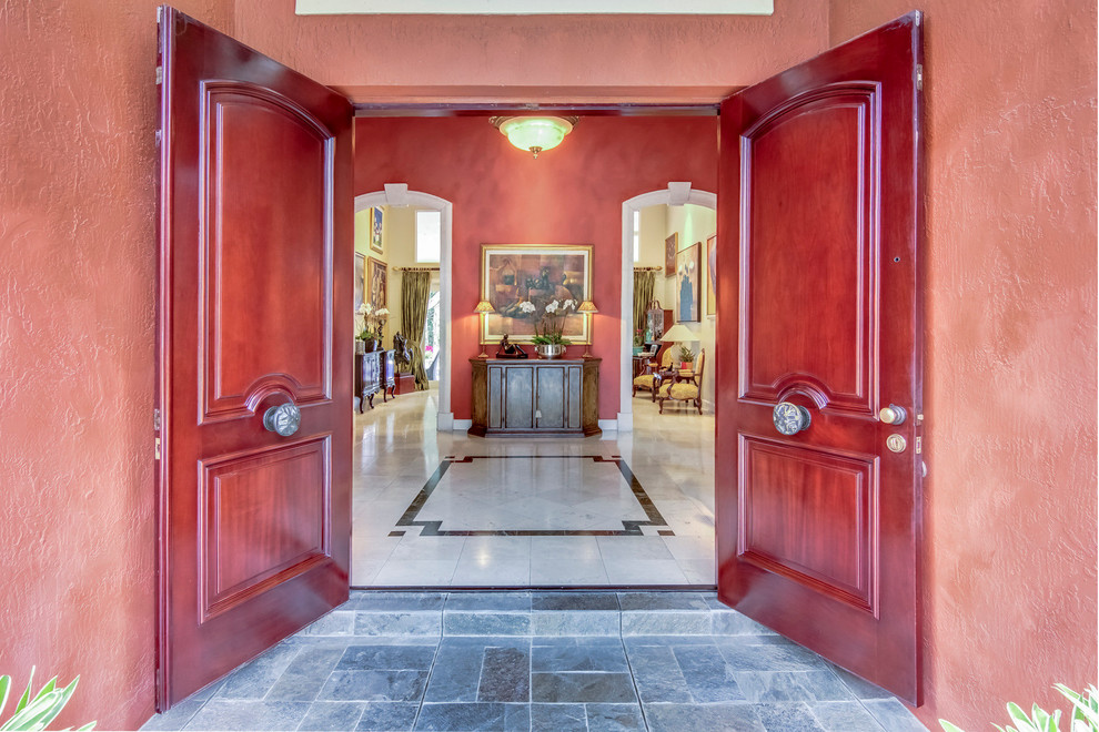マイアミにある高級な広いトラディショナルスタイルのおしゃれな玄関ロビー (赤い壁、磁器タイルの床、赤いドア) の写真