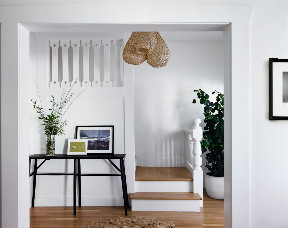 Diseño de hall nórdico de tamaño medio con paredes blancas, suelo de madera en tonos medios y suelo marrón