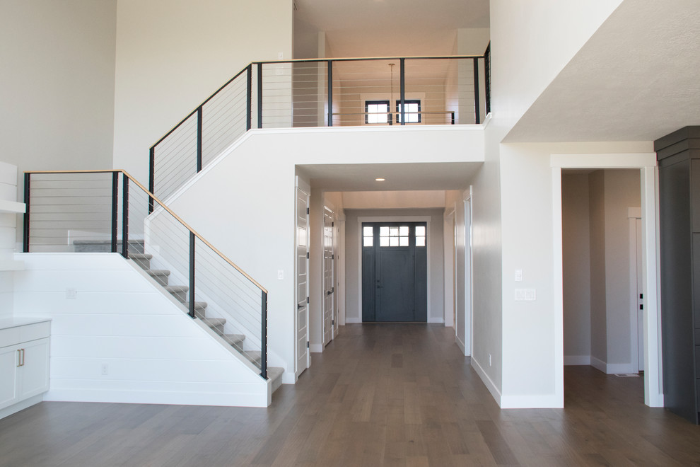 Example of a large farmhouse medium tone wood floor and brown floor entryway design in Salt Lake City with gray walls and a black front door