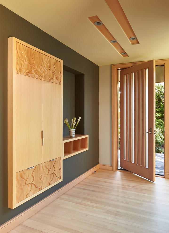 Foto de hall minimalista de tamaño medio con suelo de madera clara, puerta simple y puerta de madera en tonos medios
