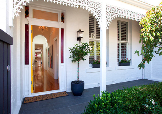 Diseño de puerta principal tradicional pequeña con paredes blancas, puerta simple y puerta amarilla