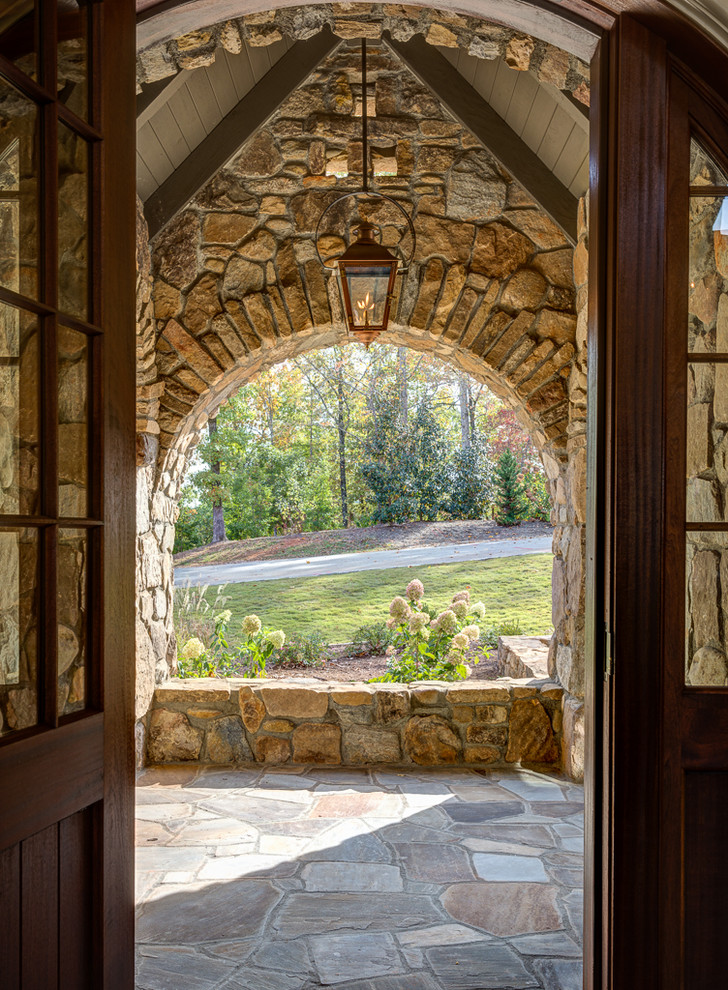 Example of a mid-sized tuscan slate floor entryway design in Other with a medium wood front door