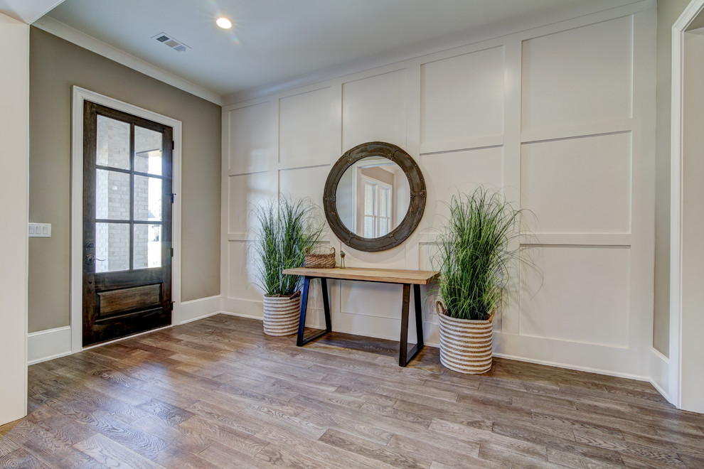 Ejemplo de entrada minimalista con paredes blancas, suelo de madera clara, puerta simple, puerta marrón y suelo marrón