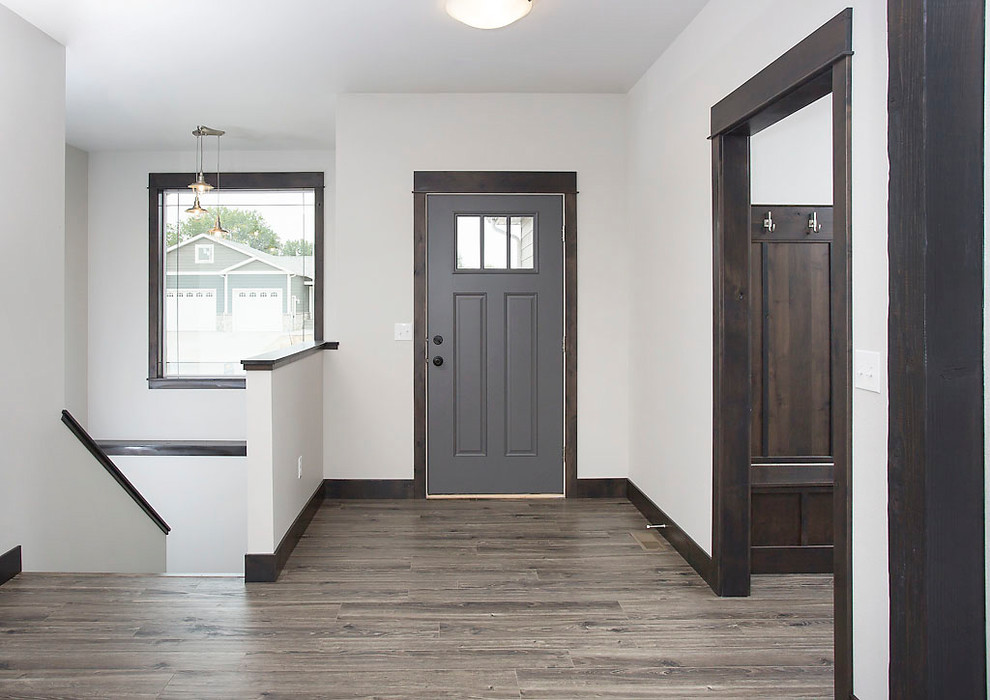 Modelo de puerta principal de estilo americano de tamaño medio con paredes grises, suelo laminado, puerta simple y suelo multicolor