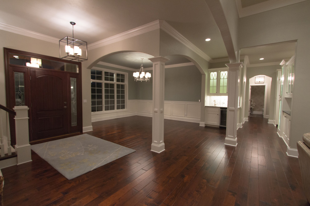 Klassische Haustür mit beiger Wandfarbe, dunklem Holzboden, Einzeltür und dunkler Holzhaustür in Milwaukee