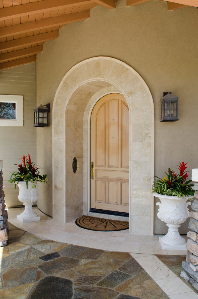 This is an example of a large mediterranean front door in San Diego with brown walls, a single front door, a light wood front door and multi-coloured floors.