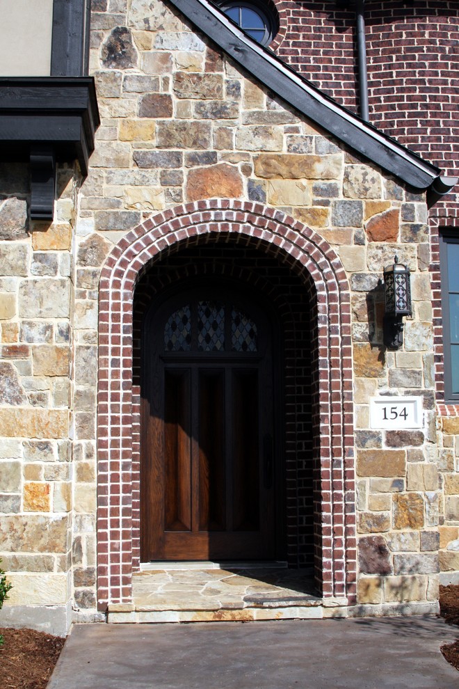 Aménagement d'une grande porte d'entrée classique avec une porte en bois brun.