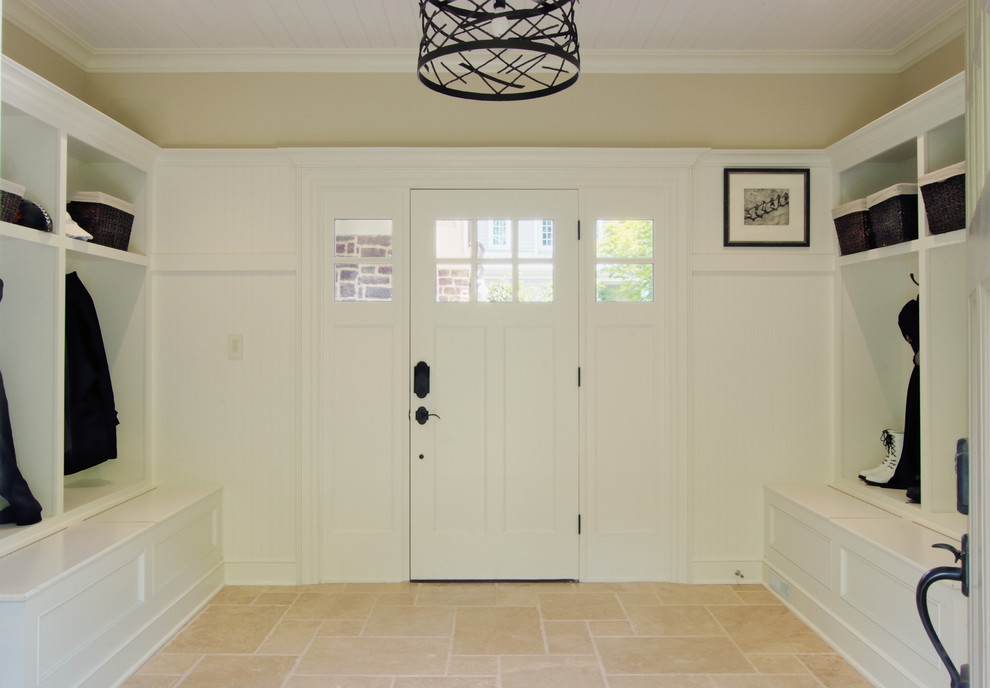 Exemple d'une grande entrée chic avec un vestiaire, un mur marron, un sol en calcaire, une porte simple, une porte blanche et un sol beige.