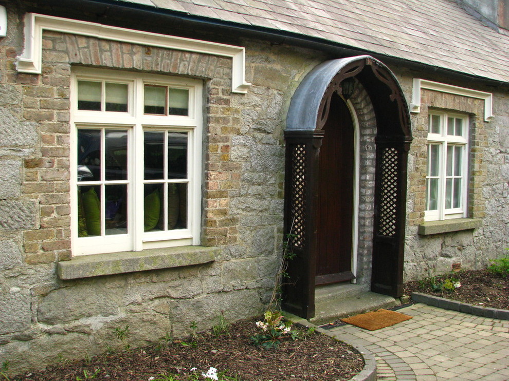 Immagine di una porta d'ingresso chic di medie dimensioni con pareti grigie, una porta singola e una porta in legno scuro