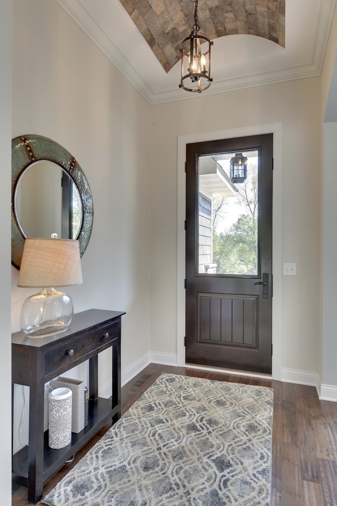 Example of a large transitional dark wood floor entryway design in Minneapolis with beige walls and a dark wood front door