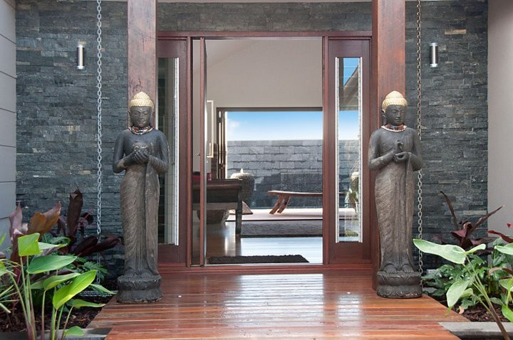 Foto de entrada asiática de tamaño medio con suelo de madera oscura, puerta pivotante y puerta de madera oscura