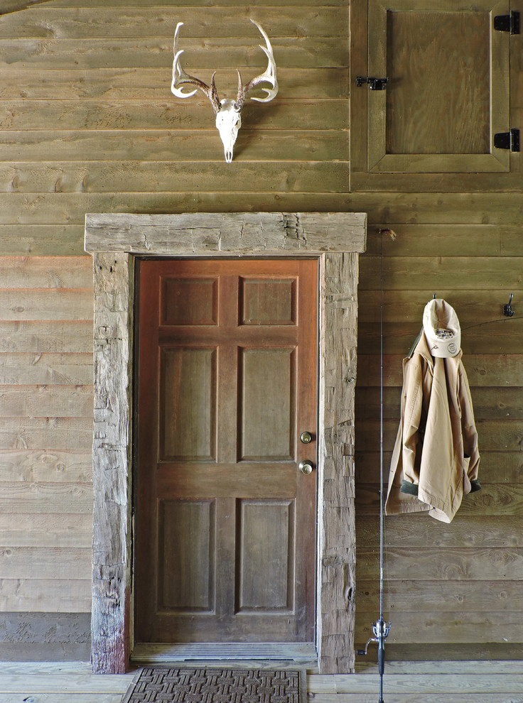 Entryway - mid-sized rustic medium tone wood floor entryway idea in Other with brown walls and a dark wood front door