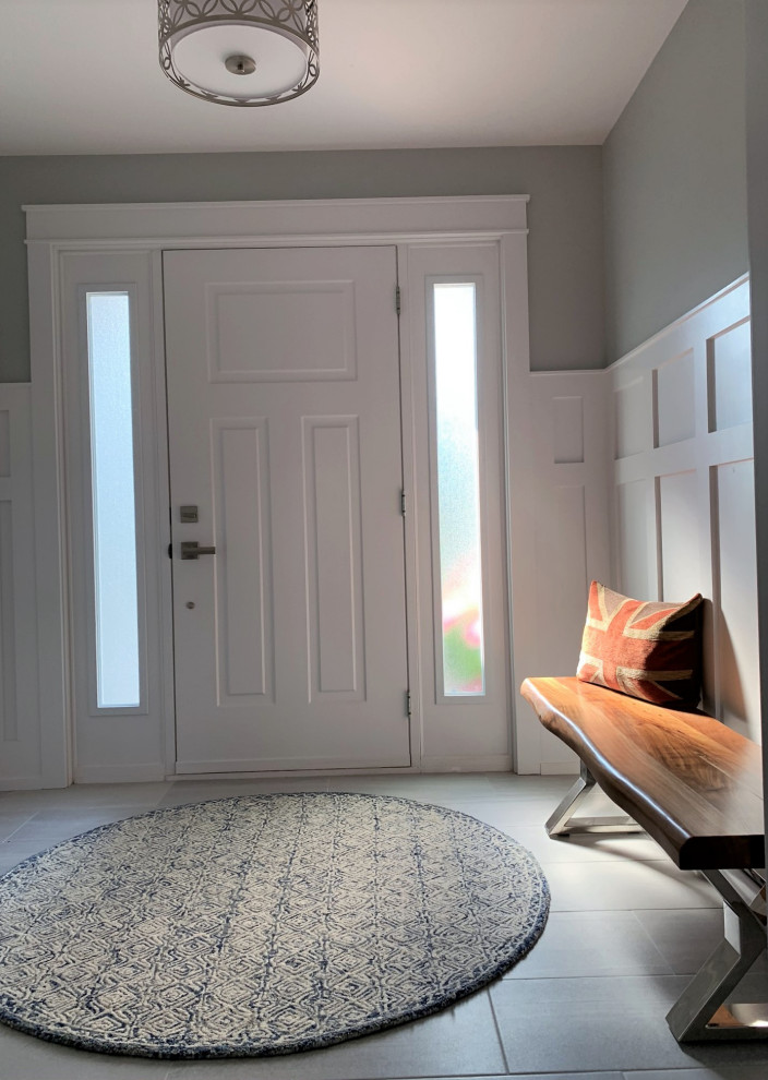 他の地域にある小さなトラディショナルスタイルのおしゃれな玄関ドア (グレーの壁、セラミックタイルの床、白いドア、青い床、羽目板の壁) の写真