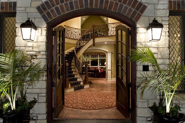 Ejemplo de puerta principal clásica grande con paredes beige, suelo de madera en tonos medios, puerta doble y puerta de madera oscura