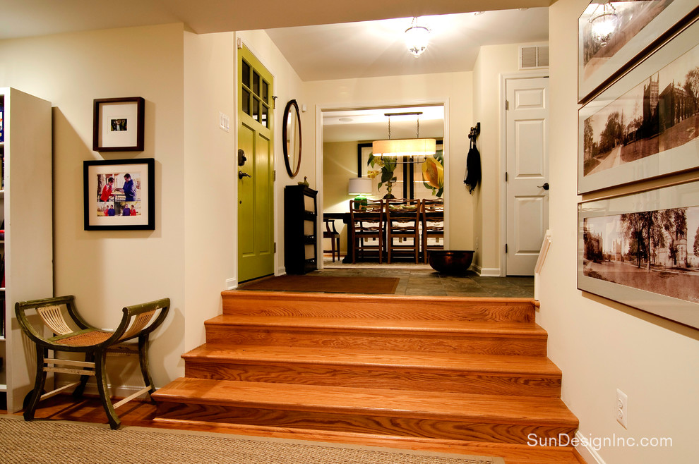 This is an example of a classic foyer in DC Metro with beige walls, light hardwood flooring and a single front door.