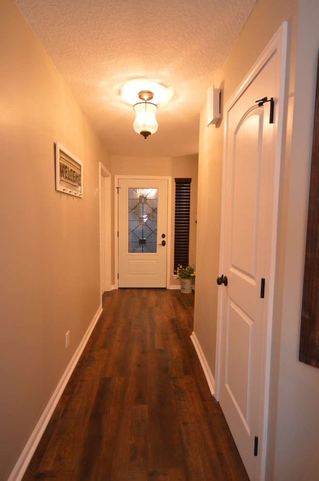 ジャクソンビルにある小さなトランジショナルスタイルのおしゃれな玄関ドア (ベージュの壁、ラミネートの床、白いドア) の写真
