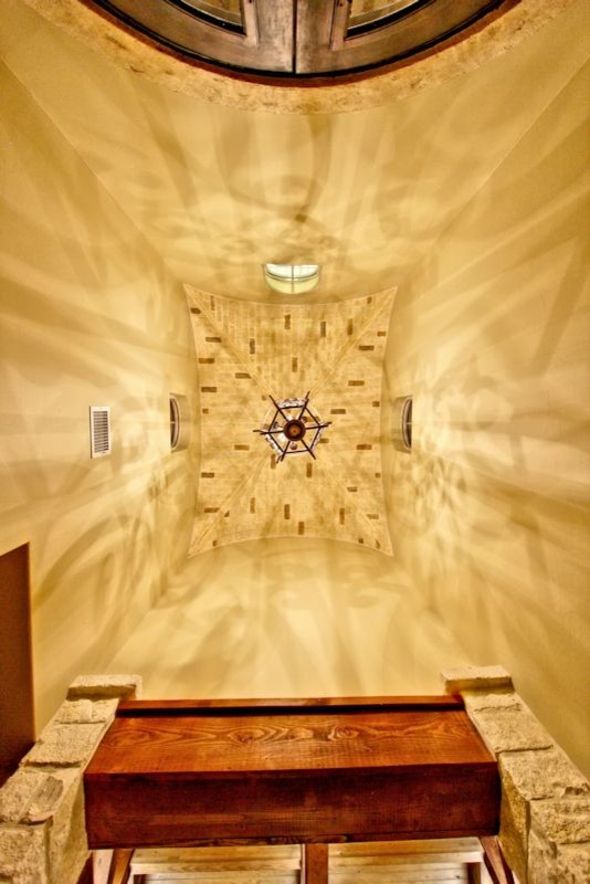 オースティンにある高級な中くらいなラスティックスタイルのおしゃれな玄関ロビー (ベージュの壁、コンクリートの床、茶色いドア) の写真