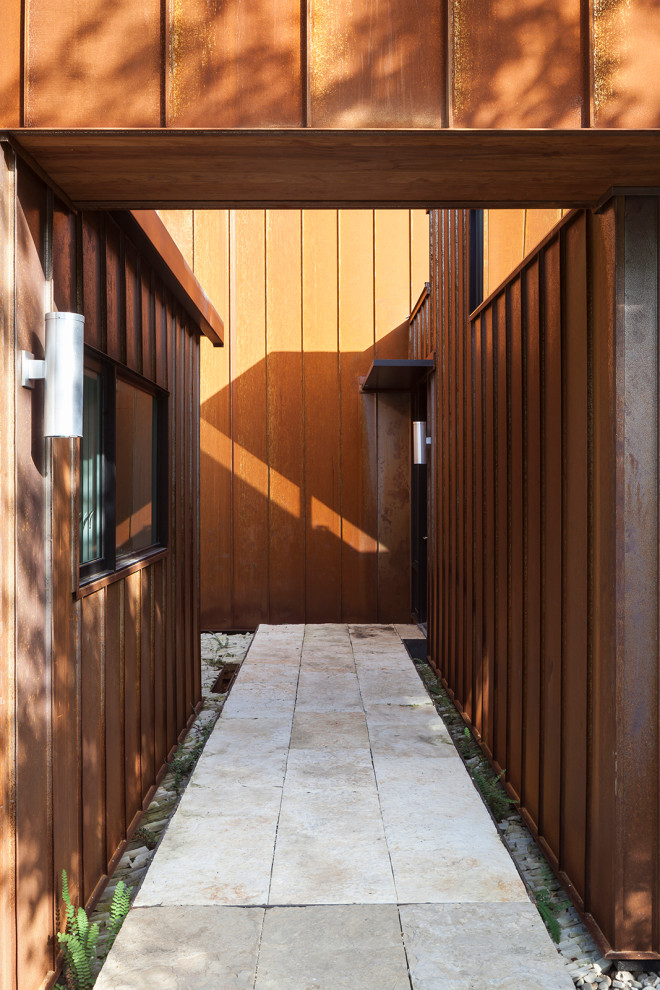 Cette image montre une grande porte d'entrée minimaliste avec mur métallisé, un sol en ardoise, une porte simple, une porte en verre, un sol gris et du lambris.